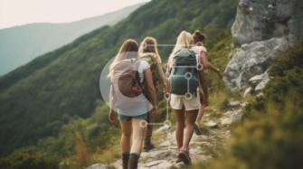 Cuatro mujeres excursionistas en un sendero de montaña rocoso con