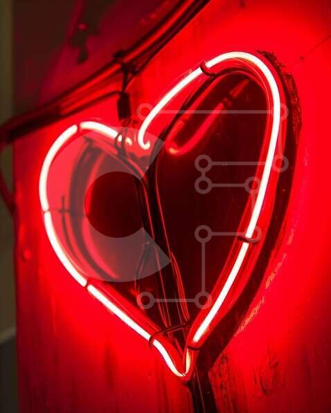 Heart-Shaped Neon Sign on Wall stock photo | Creative Fabrica